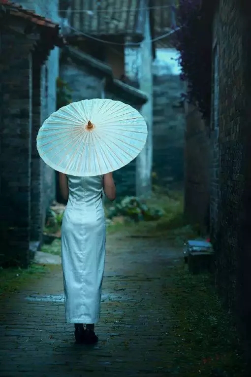 在雨中哀怨 哀怨又彷徨 她彷徨在这寂寥的雨巷 撑着油纸伞 像我一样